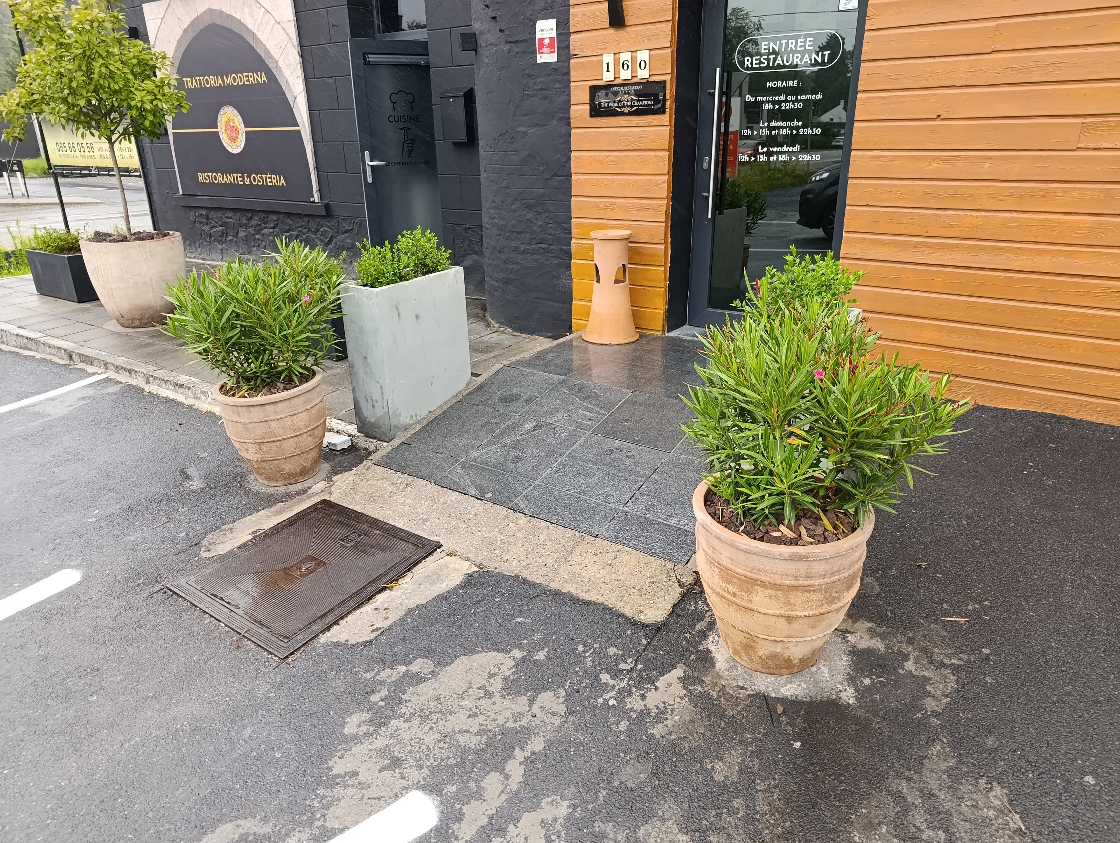 Entrée du restaurant avec oliviers et lauriers roses en pots